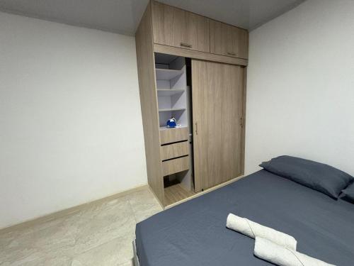 a bedroom with a bed and a wooden cabinet at Almaré apartamento en Cartagena in Cartagena de Indias