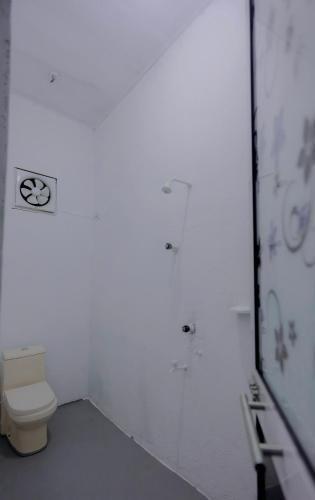 a white bathroom with a toilet and a mirror at Rilu Relax villa Arugambay in Arugam Bay