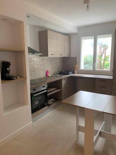 une cuisine avec une table et un comptoir dans l'établissement Joli appart proche de la mer, à Marseille