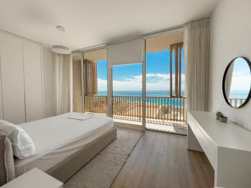 een slaapkamer met een bed en uitzicht op de oceaan bij Mèla Twin Villa Green Coast in Himare