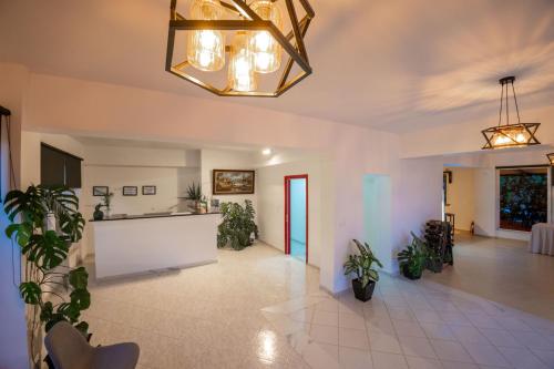 a lobby with potted plants and a chandelier at ALNES HOTEL in Sarandë
