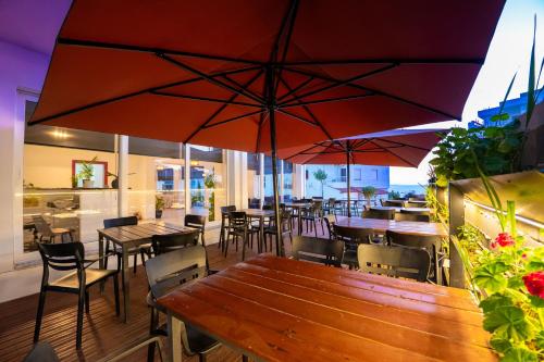a restaurant with tables and chairs and umbrellas at ALNES HOTEL in Sarandë