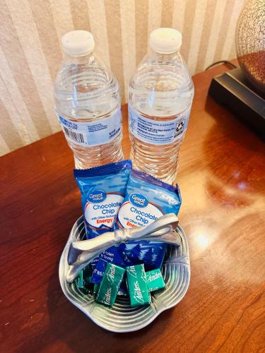 two bottles of water and toothbrushes in a basket at Nice and peaceful bedroom in Wake Village