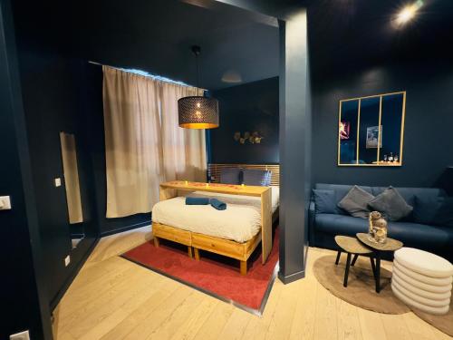 un salon avec un lit et un canapé dans l'établissement Mieuxqualhotel jacuzzi privatif La Parenthèse, à Bordeaux