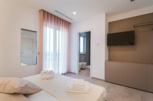 a bedroom with a bed and a flat screen tv at Eleia Domos in Monopoli