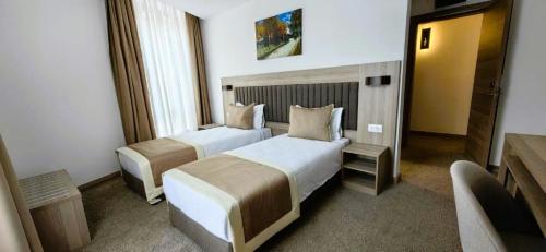 a hotel room with two beds and a window at Evelin Deluxe House in Plovdiv