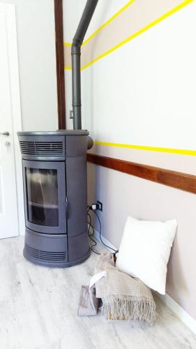 a fireplace in a room with a pillow and a rug at QuickHome Eco 2.0 in Sordevolo