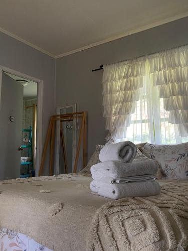 a bedroom with a bed with towels on it at Alojamiento el Arrayán in Temuco
