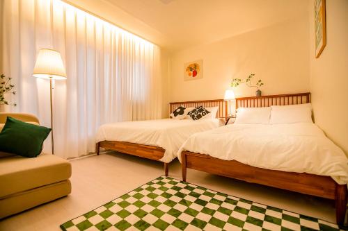 a bedroom with two beds and a checkered rug at ANNA Stay in Seoul