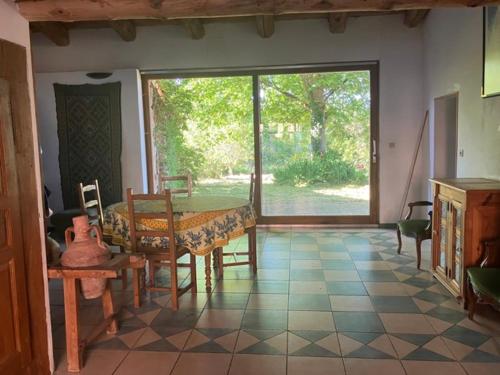 une salle à manger avec une table et une grande fenêtre dans l'établissement Maison au GRAND calme, à Beurrières