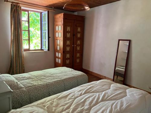 - une chambre avec 2 lits, une fenêtre et un miroir dans l'établissement Maison au GRAND calme, à Beurrières