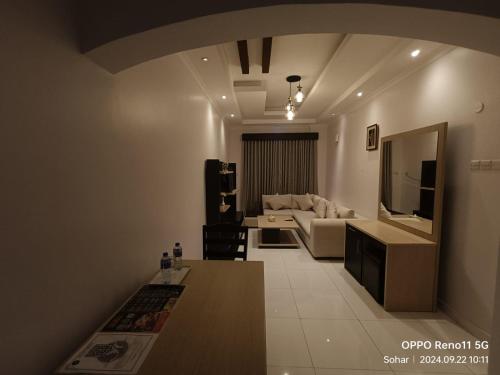 a living room with a couch and a table at SADARA HOTELS APARTMENTS in Sohar
