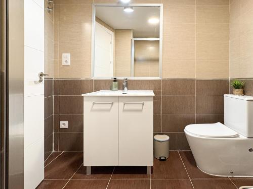 a bathroom with a toilet and a sink and a mirror at ChillaHomes 103 in Candeleda