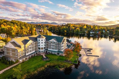 an aerial view of a large house on a lake at voco Saranac Lake NY - Waterfront by IHG in Saranac Lake