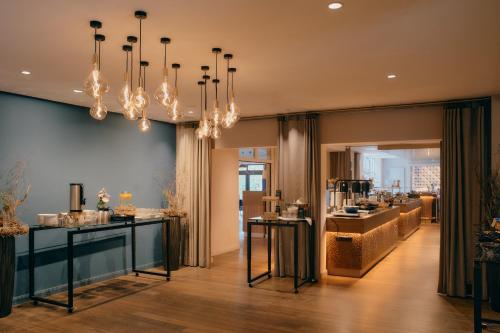 a store with a chandelier and a room with counters at Steigenberger Hotel Treudelberg Hamburg in Hamburg