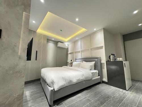 a bedroom with a large bed with white sheets at The Khushi Hotel And Resorts in Murree