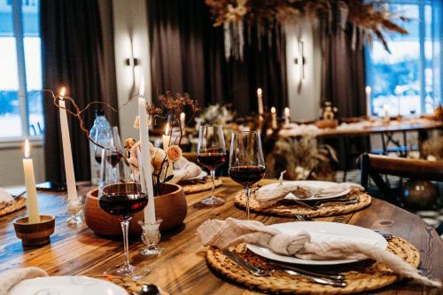 a wooden table with glasses of wine and plates of food at voco Saranac Lake NY - Waterfront by IHG in Saranac Lake