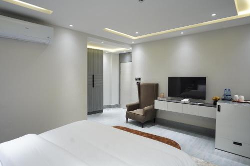 a bedroom with a bed and a flat screen tv at The Khushi Hotel And Resorts in Murree