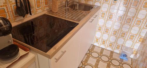 a kitchen with a sink and a stove at Attico Alvorada in Porto Santa Margherita di Caorle