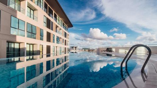a swimming pool next to a tall building at Amber Haus - deLofts Emporium - 4pax VH 13 in Kuching