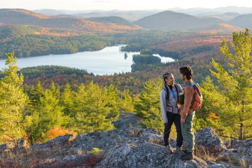 a man and a woman standing on top of a mountain at voco Saranac Lake NY - Waterfront by IHG in Saranac Lake