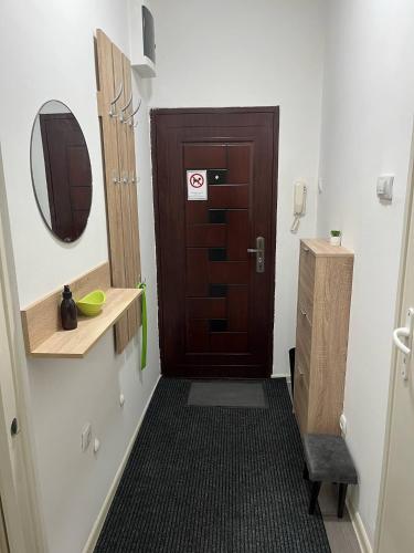 スメデレヴォにあるAria Central Apartmentの茶色のドアと木製の洗面台のあるバスルーム