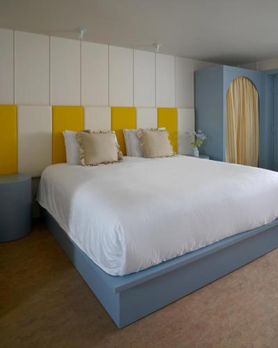 1 dormitorio con 1 cama grande de color amarillo y azul en South Beach Boutique Motel, en Southampton