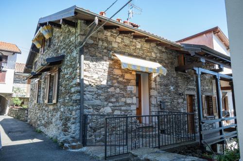 a stone house with a gate in front of it at Casa Orfea in Stresa