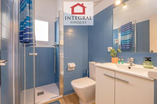 a blue bathroom with a toilet and a shower at El Refugi de Mar in Palamós