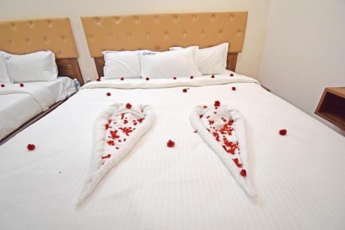 a bed with two pairs of socks with hearts on it at Cannan Residency in Pūrnānkuppam