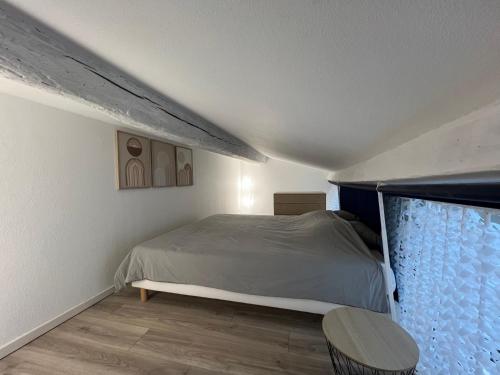 une chambre avec un lit et une grande fenêtre dans l'établissement Loft Duplex Vieil Antibes, à Antibes