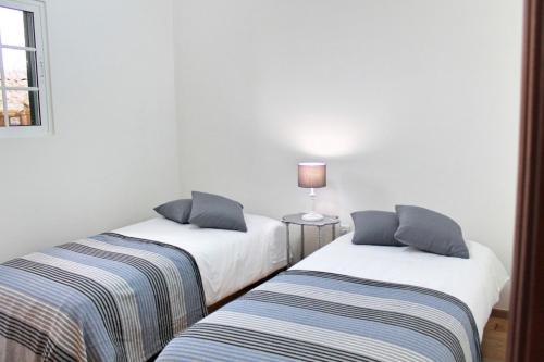 two beds sitting next to each other in a room at OurMadeira - Casa Jardim Mar, seaviews in Ponta do Sol