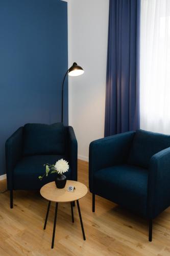 a living room with two blue chairs and a table at Fährhaus Kollmar in Kollmar