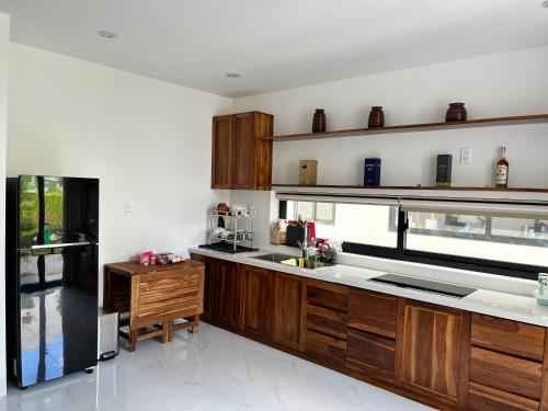 a kitchen with wooden cabinets and a counter top at Biệt thự nghỉ dưỡng Saint Simeon Long Hải in Ấp Phước Tĩnh