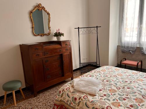 a bedroom with a dresser and a mirror on the wall at Affittacamere Sorighittu in Genova