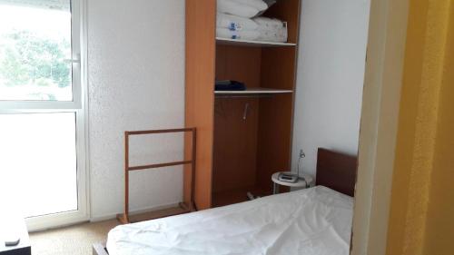 une petite chambre avec un lit et une fenêtre dans l'établissement Grand T3 entrée Arcachon rénové, à Arcachon