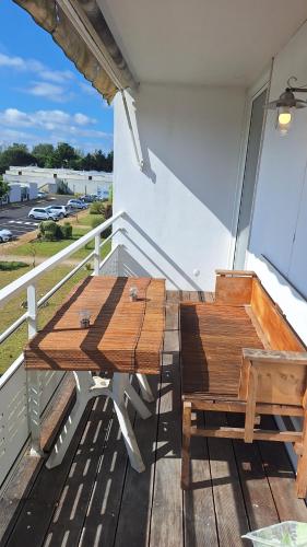 d'une table et d'un banc en bois sur un balcon. dans l'établissement Grand T3 entrée Arcachon rénové, à Arcachon
