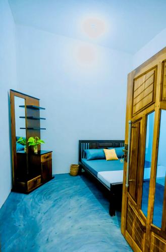 a bedroom with a bed and a wooden door at Rilu Relax villa Arugambay in Arugam Bay