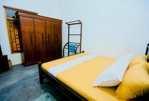 a bedroom with a bed with yellow sheets and a ladder at Rilu Relax villa Arugambay in Arugam Bay