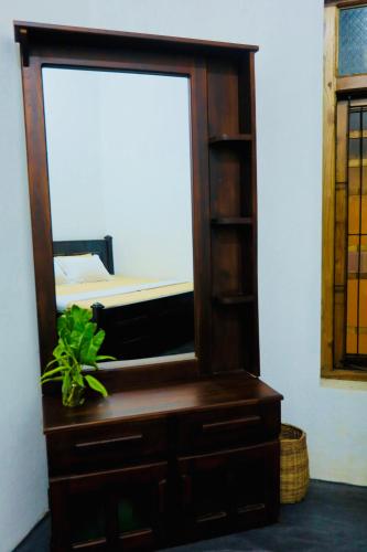 a mirror on a dresser with a bed in a room at Rilu Relax villa Arugambay in Arugam Bay