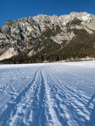 a snow covered road with mountains in the background at HOAMAT fürs HERZ, Das kleine Herz in Gröbming