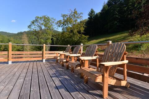 a row of wooden benches sitting on a wooden deck at Domaine du Petit Dorsbach in Soultzbach-les-Bains