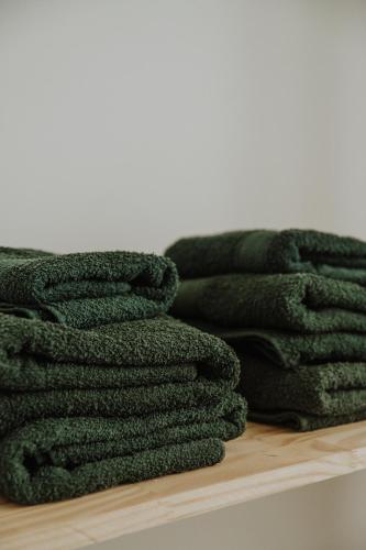 a pile of green towels sitting on a shelf at Hol Gok Patagonia in Esquel