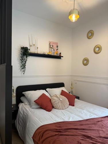 une chambre avec un lit avec des oreillers rouges et blancs dans l'établissement Le Little Italy, à Cholet