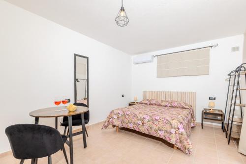 オルビアにあるSplendido Monolocale con Giardino Olbiaのベッドとテーブルと椅子のある寝室