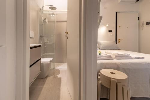 a bedroom with a bed and a shower and a toilet at La Mansardina Padovana - Historic Center in Padova