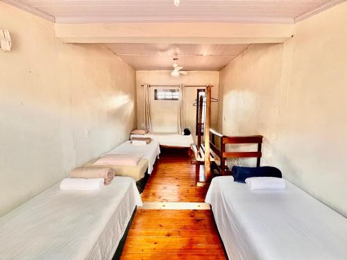 a row of beds in a room with wooden floors at Shanti - Hospedagem e Vivências Terapêuticas in Sao Jorge