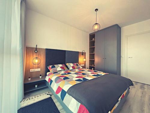 a bedroom with a large bed with a colorful comforter at Skyline Forest View Timisoara in Timişoara