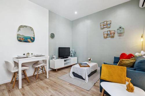un salon avec un canapé bleu et une table dans l'établissement Appartement La Citadine - Welkeys, à Antibes