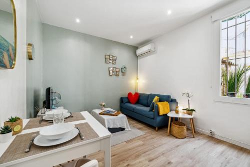 un salon avec un canapé bleu et une table dans l'établissement Appartement La Citadine - Welkeys, à Antibes